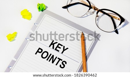 On a sheet of diary inscription KEY POINTS, next to there are crumpled sheets for notes, pencil and glasses.
