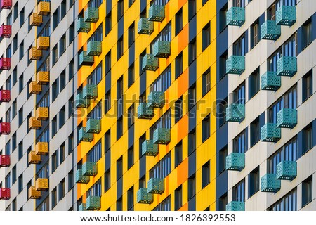 Colorful pattern from windows and balconies in modern residential building Royalty-Free Stock Photo #1826392553