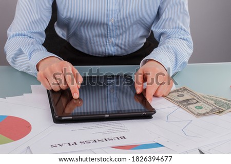 Business woman working with tablet pc at office. Accountant woman sitting at office table and using digital tablet.