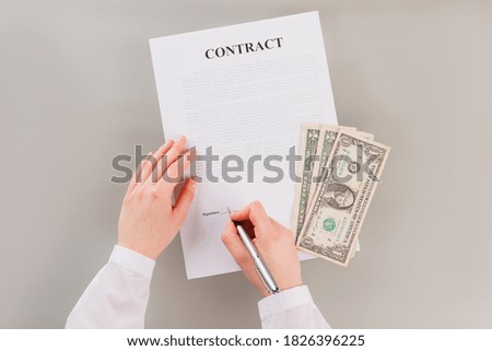 Woman is signing a contract to get a lot of money. Bribe for signing contract.