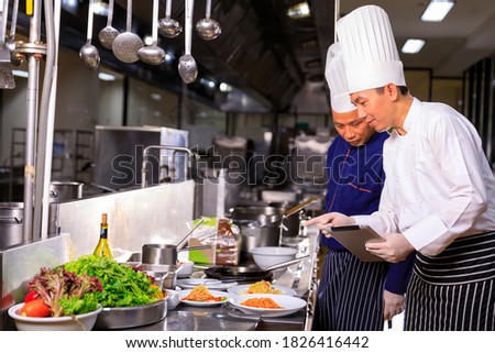 The male executive male discussing the menu with his colleague in the kitchen. Royalty-Free Stock Photo #1826416442