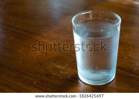 Glasses of cool drinking water on wooden table.