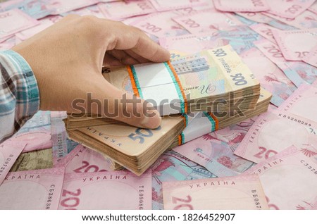 close-up of a woman's hand and a bundle of hryvnias. Financial concept. Ukrainian banknotes of 500 and 200 hryvnia. Many Ukrainian banknotes. Money background.