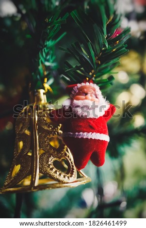 Decorated Christmas tree on blurred, sparkling santa fur doll and Closeup Golden bell with fairy green background. shallow depth in field
