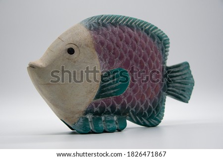 Wooden rainbow fish against a light background