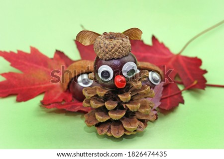 
funny owl from pine cone and acorn hat tinker with children in autumn Royalty-Free Stock Photo #1826474435