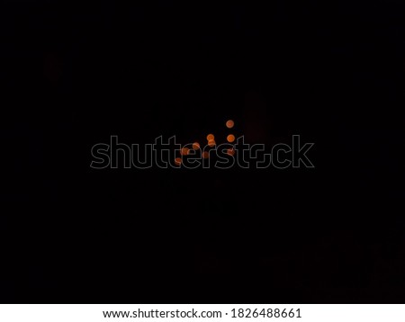 The photo of the orange dot with a black background is the result of a hand-shot of my cell phone camera