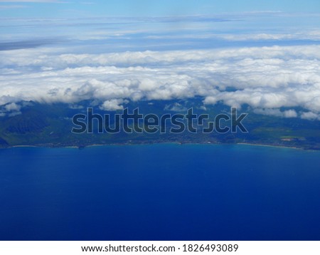 Aerial of West coast of Oahu with views of Waiane, Makaha, and Maili with clouds hovering over the island.