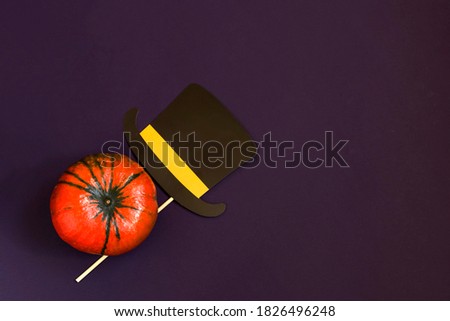 Happy Halloween text in wooden letters, pumpkin on dark background, paper hat, flat lay. Atmospheric image. Autumn postcard. Copy space