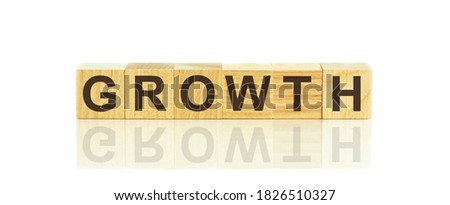 Wooden Blocks with the text: GROWTH. The text is written in black letters and is reflected in the mirror surface of the table. New business relaunch startup concept.