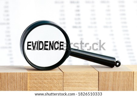 Look closely and Evidence with a magnifying glass. Looking through a magnifying glass at the word Evidence, a business concept. Magnifying glass on the background of columns of numbers. Royalty-Free Stock Photo #1826510333