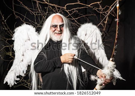 Bearded Man with angel wings. Senior man posing with angel wings. Demon head isolated on black. Mysterious warrior enchanted to have thorns on his face
