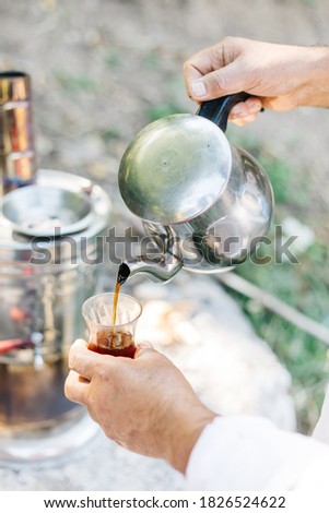 enjoying tea in a samovar outdoors