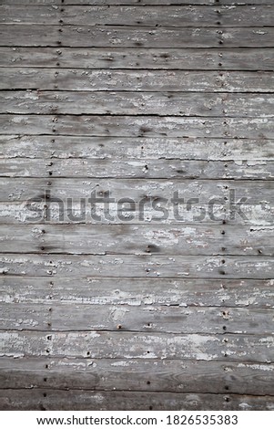 The texture of the old plank wall with the remains of white paint