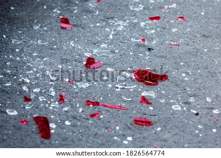Headlight fragments are seen on the ground in a car crash aftermath. Royalty-Free Stock Photo #1826564774