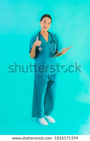 Portrait beautiful young asian doctor woman with empty paper board for copy space on blue isolated background - Healthcare in hospital and clinic concept