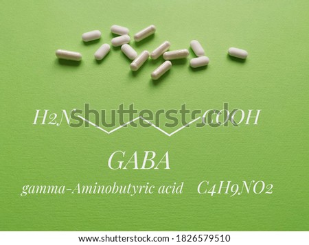 Structural chemical formula of gamma-aminobutyric acid (or GABA) molecule with white pills. GABA is a naturally occurring amino acid that works as a neurotransmitter; used as a dietary supplement. Royalty-Free Stock Photo #1826579510