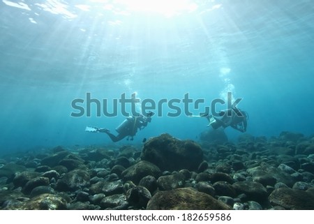 Scuba diver passing the coral reef as bubble rising.