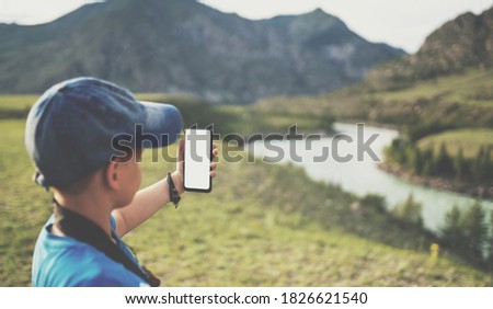 little boy taking pictures in the mountains. mock up phone image