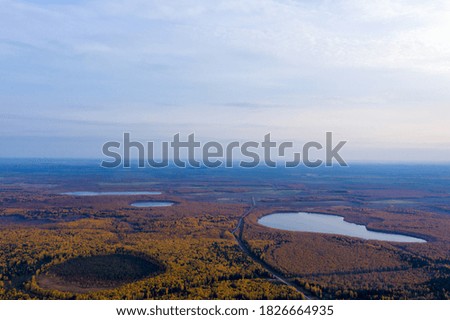 Aerial photo of some lakes surrounded by colorful forest in autumn.