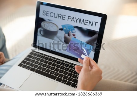 Secure payment. Close up of female customer cardholder hand with plastic card at laptop providing online non-cash transactions, paying bills, using internet banking app, buying goods in virtual store Royalty-Free Stock Photo #1826666369