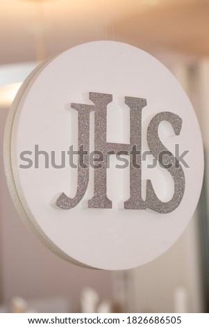 The Jesus Hominum Salvator sign hanging on one of the mirrors at a reception venue during the First Holy Communion gathering during a warm, sunny spring day