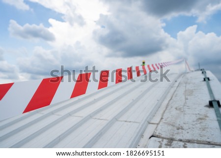 red tape for restrict area metal sheet rooftop in cloudy weather blue sky stock photo