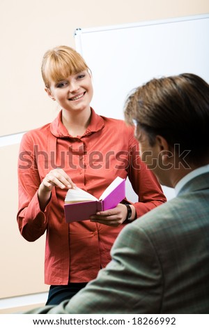 Friendly woman looking at her companion with smile during conversation