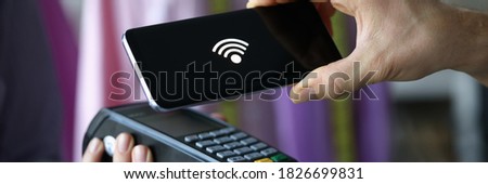 Close-up of terminal and cashless pay. Smartphone with sign on screen. Cashier machine to withdrawals money. Nfc technology counter. Finance and purchase. Contactless payment concept