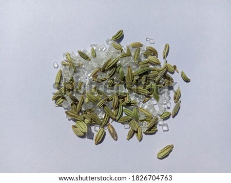 isolated white background picture of green fennel saunf and sugar.