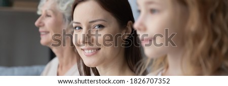 Wide image close up head shot smiling beautiful young woman looking at camera, posing with pretty little daughter and mature mother, free generations of women standing in row, growing process Royalty-Free Stock Photo #1826707352