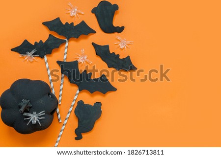 Happy halloween holiday. Halloween decorations, black and white pumpkins, bats, ghosts on a black background. Halloween party greeting card mockup with copy space. Halloween greeting banner