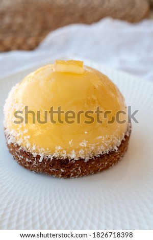 Small yellow  lemon ball tart from French pastry shop close up