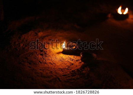 Picture of a traditional Pakistani / Indian oil lamp made from clay, with a cotton wick dipped in ghee or vegetable oils.