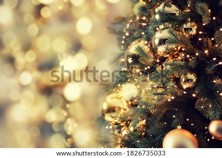 Decorated christmas tree pine on blurred gold background bokeh light banner.