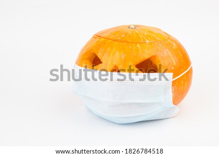 Coronavirus Halloween Pumpkin. Halloween jack o lantern wearing a covid-19 face mask on white background.