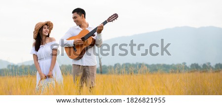 Happy asian couple playing  guitar in picnic day at park , Travel  holiday summer lifestyle healthy Concept   , Banner for text