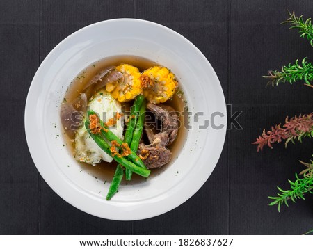 Top view of Beef Bulalo, a popular a beef soup dish from the Philippines. It is a light colored soup with beef shanks and marrow. Royalty-Free Stock Photo #1826837627