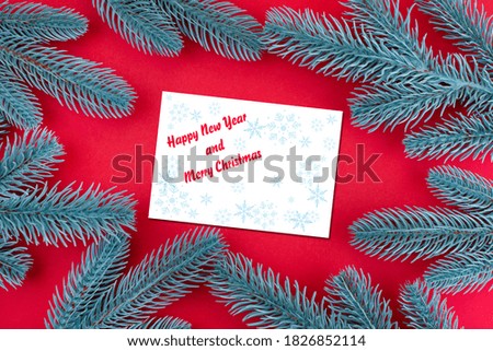 Happy New Year and Merry Christmas! Red festive background with branches of a Christmas tree and place for text. Christmas flyer template.