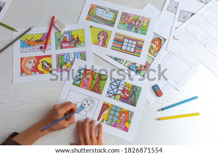 An animator painter draws a color storyboard for a comic book or movie. An illustrator seated at his desk creates a storyboard for a cartoon. 