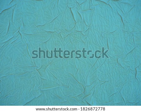 Light blue texture, gold-plated surface made of crumpled fabric. Crumpled, textured background with cracks and irregularities for decoration and design . Top view, copy space.