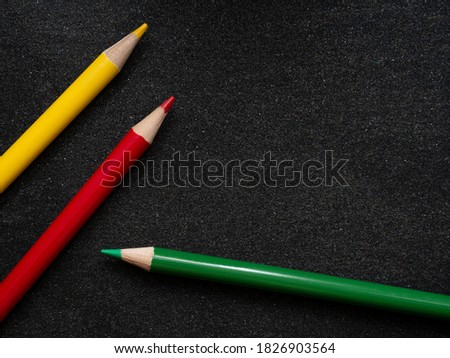 Bright colored pencils on a dark black background. Seven colors of the rainbow. Back to school. Education and creativity. Drawing and art. Free space for text.