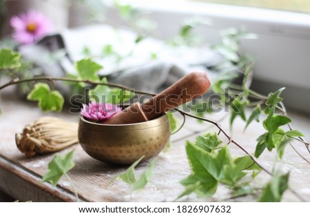 Tibetan singing bowl in sound therapy close up, flowers and nature, cozy and warm blanket, sweater Royalty-Free Stock Photo #1826907632