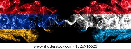 Armenia vs Luxembourg smoky mystic flags placed side by side. Thick colored silky abstract smoke flags