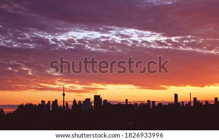The Toronto skyline surrounded by clouds during sunset.