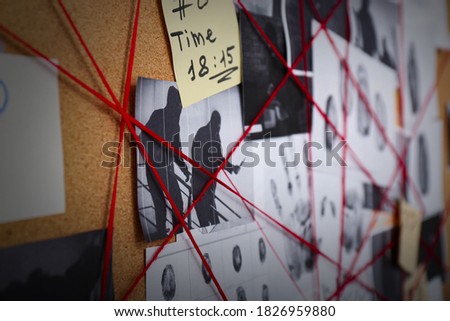 Detective board with crime scene photos, fingerprints and red threads, closeup