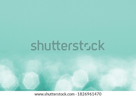 Blurred turquoise background with bokeh effect, full screen image.