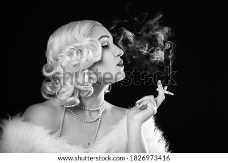 luxury young woman smoking on black background, monochrome