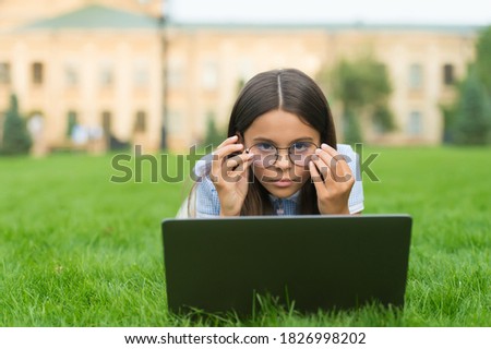 anti-reflective coating glasses. online education. back to school. teen girl use computer in park. child in glasses with notebook. new technology in modern life. serious kid work on laptop.