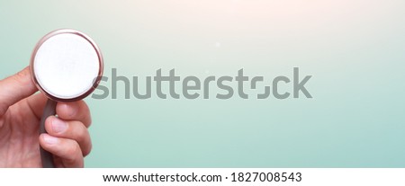 Female hand holds a stethoscope on a blue background. Concept doctor, doctor's appointment, virus, treatment, diagnosis. Banner. Copy space. Place for text